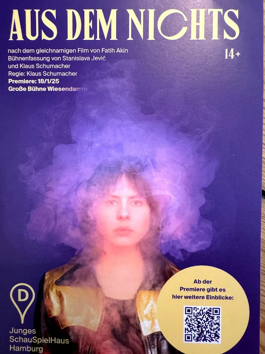 Ein Plakat für das Theaterstück „Aus dem Nichts“ vom Jungen Schauspielhaus. Darauf der Oberkörper einer Frau, der Kopf leicht im Nebel mit lila Hintergrund.